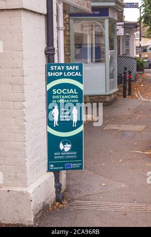 Segnaletica che spiega le regole di allontanamento sociale nel centro del villaggio di Woodstock, West Oxfordshire, Regno Unito Foto Stock