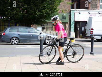 Oxted, UK, 5 AGOSTO 2020, UNA signora chiacchiera sul suo telefono cellulare mentre si siede su una bicicletta a Oxted mentre godendo il caldo all'inizio dell'onda di calore che è prevista per i prossimi giorni.la temperatura oggi è 23C.Credit: Keith Larby/Alamy Live News Foto Stock