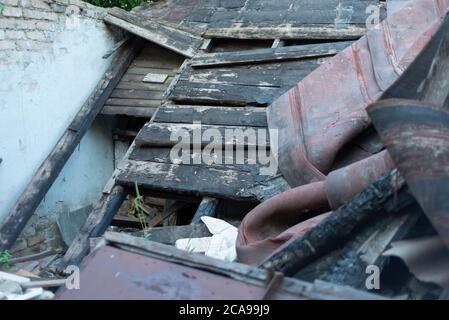 il tetto dell'edificio bruciato crollò. I detriti riempirono la stanza della casa. Rovine, mattone bianco, parete, texture, carta da parati, disastro d'epoca Abandone Foto Stock