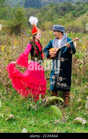 Uomo kazako suonando e cantando dombra per una donna, il kazako villaggio etnografico Aul Gunny, Talgar città, Almaty in Kazakistan e in Asia centrale, per editori Foto Stock