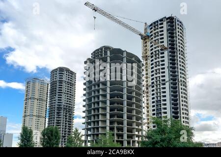 Edificio residenziale a più piani. Finestre e pareti in casa in costruzione. Ingegneria civile moderna. Industria degli edifici. Case incompiite in T Foto Stock
