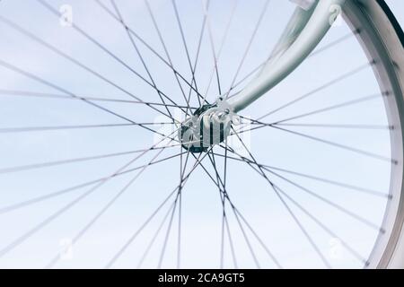 Primo piano di una ruota di bicicletta su uno sfondo blu del cielo Foto Stock