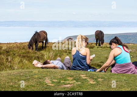 Exmoor National Park - giovani e pony che si rilassano sul punto più alto di Exmoor, Dunkery Beacon 1705 piedi 520 metri, Somerset UK Foto Stock