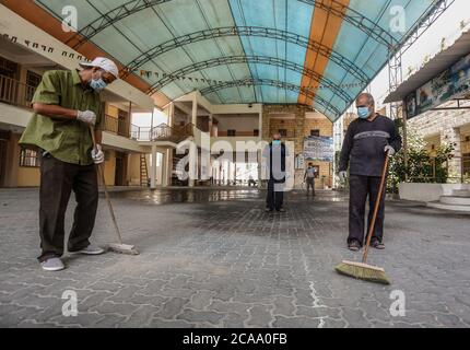 Gaza, Palestina. 05 agosto 2020. I lavoratori indossano maschere facciali e guanti per sanificare una scuola prima che inizi il nuovo anno scolastico, tra le preoccupazioni della diffusione del coronavirus (Covid-19) a Khan Yunis. Credit: SOPA Images Limited/Alamy Live News Foto Stock