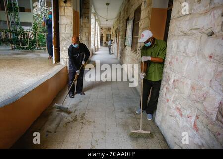 Gaza, Palestina. 05 agosto 2020. I lavoratori indossano maschere facciali e guanti per sanificare una scuola prima che inizi il nuovo anno scolastico, tra le preoccupazioni della diffusione del coronavirus (Covid-19) a Khan Yunis. Credit: SOPA Images Limited/Alamy Live News Foto Stock