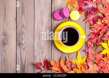 Tazza con caffè nero caldo, macaroon su tavolo di legno con autunno caduto giallo, arancio e foglie rosse Flat Lay Top vista Mock up Ciao settembre Foto Stock