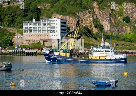 Brixham Trawler E198 MARGHERITA di LADRAM che ritorna al porto. Pescherecci da traino nel porto di Brixham. Grande edificio e scogliere sullo sfondo. Formato orizzontale Foto Stock