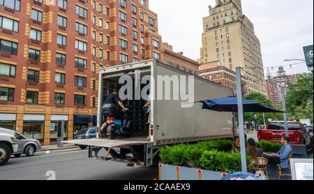 I lavoratori della compagnia di condivisione del ciclomotore Revel rimuovono il loro inventario dalle strade, visto nel quartiere Chelsea di New York venerdì 31 luglio 2020. Dopo diverse morti Revel ha annunciato che sta temporaneamente chiudendo le sue attività a New York fino a quando non rafforzano i protocolli di sicurezza e responsabilità dei piloti. (© Richard B. Levine) Foto Stock