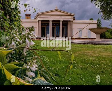 Il piccolo Palazzo Charlottenhof dopo la pioggia con nuvole scure sullo sfondo Foto Stock