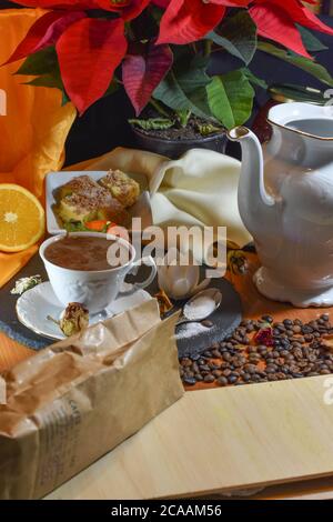 Primo piano di un tavolino da caffè con teiera bianca tradizionale, piante e caffè Foto Stock