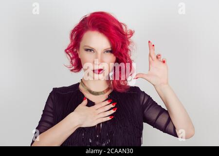 Un bugiardo. Donna Sly testimone fare una falsa promessa o testimonia falso gesto mani. Rosso testa riccia bob hairstyle ragazza isolato grigio chiaro bianco backg Foto Stock