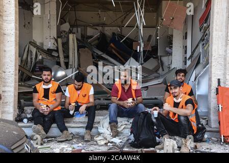 Beirut, Libano, 5 agosto 2020. Un equipaggio pulito si rompe per il pranzo durante uno sforzo di ripulire dopo una catastrofica esplosione che ha distrutto grandi aree della periferia settentrionale della città, ferendo oltre 6000 persone, con un bilancio di oltre duecento morti. Elizabeth Fitt Foto Stock