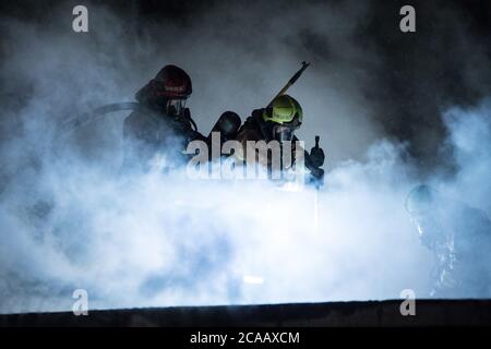 Vigili del fuoco battaglia casa fuoco sul tetto. Foto Stock