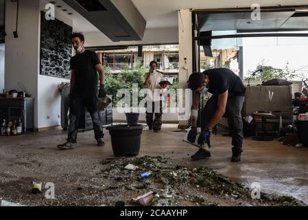 Beirut, Libano, 5 agosto 2020. Le persone lavorano per eliminare i detriti dal loro appartamento direttamente di fronte al porto della capitale, luogo di una catastrofica esplosione che ha distrutto gran parte dei quartieri settentrionali della città. Elizabeth Fitt Foto Stock