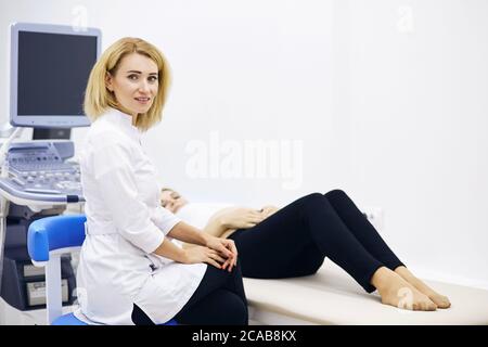un'infermiera giovane e bella che siede nex alla donna incinta al chiuso. primo piano foto. Foto Stock