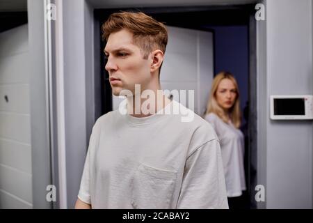 coppia sposata stanca l'una dell'altra, sono entrambi offesi. hanno litigato a casa, accanto alla porta Foto Stock