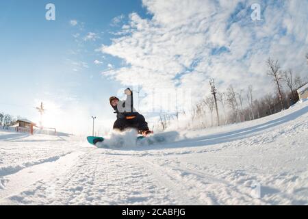 lo snowboarder senza paura guida velocemente. foto a tutta lunghezza. foto in azione. sosta pericolosa. l'uomo finisce lo snowboard Foto Stock