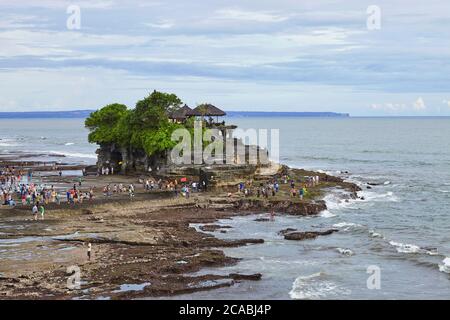 I turisti sparsi nella posizione turistica del tempio indù a Tanah Lot, Bali. Foto Stock