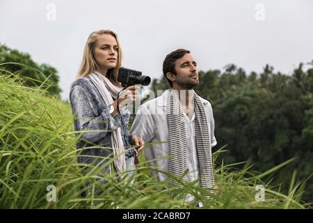 Asia, Indonesia, Bali, giovane coppia caucasica, indossa abbigliamento casual elegante, godendosi una passeggiata lungo il famoso crinale di Campuan, uno dei ben noti a. Foto Stock