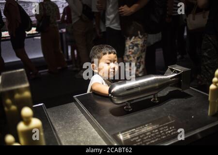 Un bambino sta toccando un modello in scala ridotta della bomba atomib chiamata 'Little Boy' che è stato fatto cadere su Hiroshima il 6 agosto 1945, al Museo della Pace di Hiroshima. Il Museo della Pace di Hiroshima si trova nel Parco Memoriale della Pace di Hiroshima ed è stato istituito nel 1955, 10 anni dopo il bombardamento atomico a Hiroshima e Nagasaki. Foto Stock