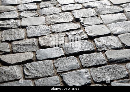 Un antico marciapiede rivestito di pietre per pavimentazione. Foto Stock