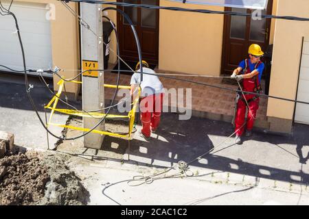 Processo di installazione di nuovi traliccio di elettricità in cemento per strada, Ungheria, Europa Foto Stock