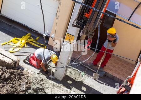 Processo di installazione di nuovi traliccio di elettricità in cemento per strada, Ungheria, Europa Foto Stock