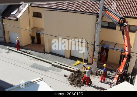 Processo di installazione di nuovi traliccio di elettricità in cemento per strada, Ungheria, Europa Foto Stock