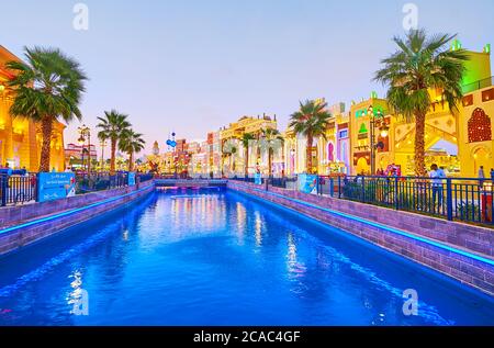 DUBAI, Emirati Arabi Uniti - 5 MARZO 2020: Le luci colorate decorano il canale del Global Village Dubai, fiancheggiato da padiglioni commerciali e di intrattenimento di diverse c. Foto Stock