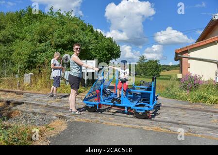 Una famiglia britannica che si gode una giornata fuori su un sistema di velorail in Francia Foto Stock