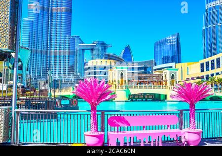 DUBAI, Emirati Arabi Uniti - 3 MARZO 2020: La panca di colore rosa con palme artificiali sul vicolo pedonale del lago Burj, il 3 marzo a Dubai Foto Stock