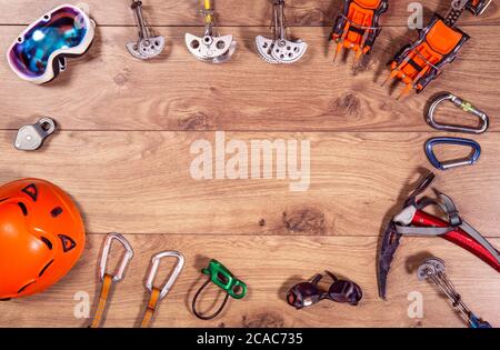 Attrezzatura per arrampicata e avventura vista in piano. Vista dall'alto di attrezzi di montaggio estremi come casco, camponi, ascia da ghiaccio, moschettone, occhiali. Foto Stock
