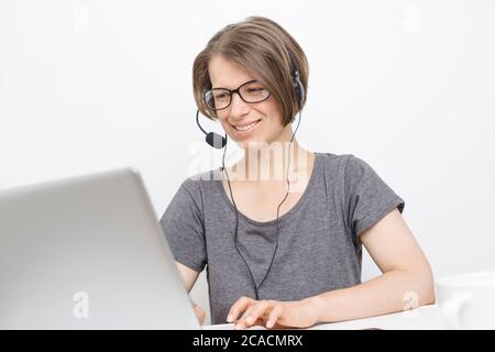 Donna che parla in cuffia chattare online utilizzando un computer portatile. Videoconferenza. Webinar. Foto Stock