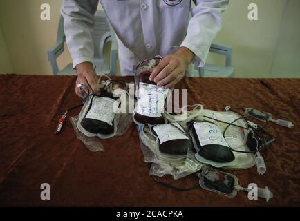 Gaza, Palestina. 05 agosto 2020. Un operatore sanitario è visto con sacche di sangue donate dai palestinesi per i feriti dopo l'esplosione del Libano. I palestinesi donano sangue durante un evento organizzato dal comune, dalla Mezzaluna Rossa e dal Ministero della Salute a Khan Yunis nella striscia di Gaza meridionale, A sostegno del Libano dopo una massiccia esplosione che ha scosso la sua capitale. Credit: SOPA Images Limited/Alamy Live News Foto Stock