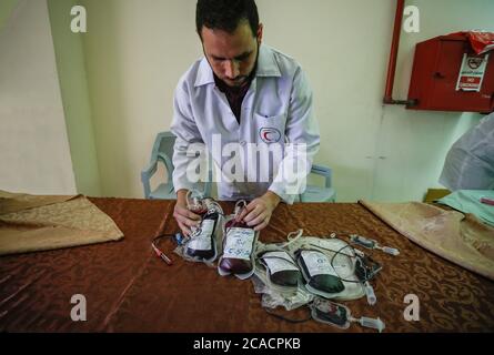 Gaza, Palestina. 05 agosto 2020. Un operatore sanitario è visto con sacche di sangue donate dai palestinesi per i feriti dopo l'esplosione del Libano. I palestinesi donano sangue durante un evento organizzato dal comune, dalla Mezzaluna Rossa e dal Ministero della Salute a Khan Yunis nella striscia di Gaza meridionale, A sostegno del Libano dopo una massiccia esplosione che ha scosso la sua capitale. Credit: SOPA Images Limited/Alamy Live News Foto Stock