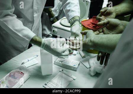 Gaza, Palestina. 05 agosto 2020. Un operatore sanitario controlla i palestinesi prima di permettere loro di donare sangue. I palestinesi donano sangue durante un evento organizzato dal comune, dalla Mezzaluna Rossa e dal Ministero della Salute a Khan Yunis, nella striscia di Gaza meridionale, a sostegno del Libano, dopo una massiccia esplosione che ha scosso la sua capitale. Credit: SOPA Images Limited/Alamy Live News Foto Stock