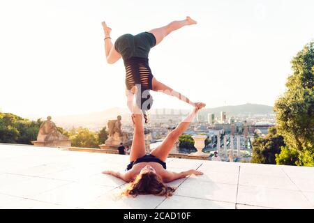 Due belle donne che fanno acroyoga in città Foto Stock