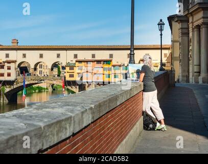 Donna artista pittura acquerello di Ponte Vecchio sul fiume Arno a Firenze Toscana, Italia Foto Stock