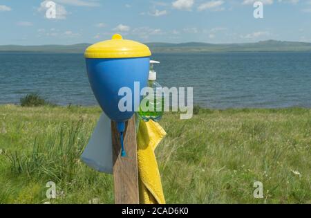 lavabo a mano sulla riva di un bellissimo lago. fuoco selettivo. concetto di ricreazione all'aperto e ecoturismo. Foto Stock