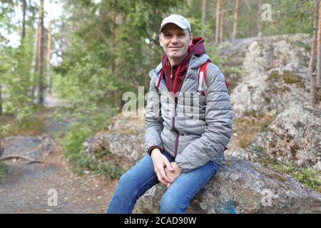 Backpacker che riposa su una roccia nella foresta Foto Stock