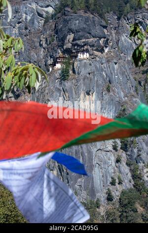 Bhutan, Paro. Bandiere di preghiera colorate lungo il sentiero escursionistico fino al monastero di Tiger's Nest, uno dei siti religiosi più sacri del Bhutan. Foto Stock