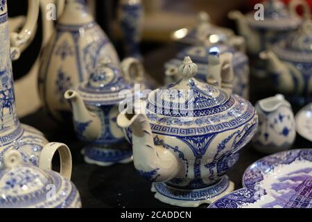 Primo piano su molti teapots cinesi tradizionali. Sfocatura dello sfondo Foto Stock