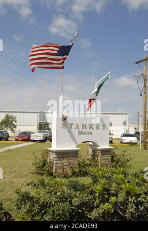 Matamoros Messico, aprile 2006: Le bandiere degli Stati Uniti e del Messico volano di fronte a una fabbrica della società statunitense Starkey, produttrice di apparecchi acustici. ©Bob Daemmrich Foto Stock