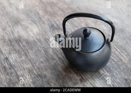 Primo piano su una pentola di tè cinese di rame su vecchio tavolo di legno. Sfocatura dello sfondo Foto Stock