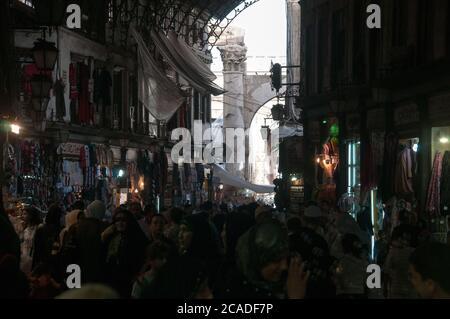 Gli acquirenti siriano a piedi attraverso la trafficata e affollata al mercato Hamidiyah, un tipico mezzo souq orientale nella città vecchia di Damasco, Siria. Foto Stock