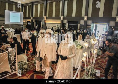 Medan, Nord Sumatra, Indonesia. 6 agosto 2020. Una sposa e uno sposo che indossano maschere facciali durante una simulazione di un ricevimento nuziale per applicare ai protocolli di salute nella nuova era normale ad un Medan, Sumatra del Nord il 6 agosto 2020. Il governo indonesiano ha imposto una nuova serie di regolamenti, soprannominati la "nuova normalità" che è prevista per essere attuata in fasi o il numero di infezioni può riaprire le imprese, pur rispettando rigorosi protocolli di codice sanitario. Credit: Albert Ivan Damanik/ZUMA Wire/Alamy Live News Foto Stock