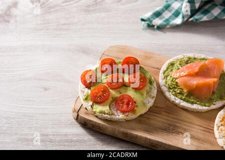 Assortimento di ingredienti su torte di riso soffiato su tavolo di legno Foto Stock