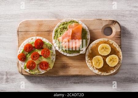Assortimento di ingredienti su torte di riso soffiato su tavolo di legno Foto Stock