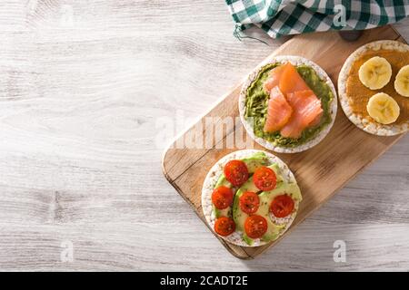 Assortimento di ingredienti su torte di riso soffiato su tavolo di legno Foto Stock