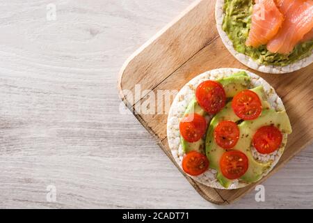 Assortimento di ingredienti su torte di riso soffiato su tavolo di legno Foto Stock